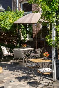 a table and chairs with an umbrella on a patio at Cé La Vie in Maaseik