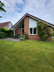 a brick house with a lawn in front of it at Haus Teelke in Papenburg
