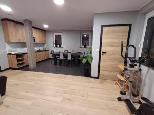 a living room with a gym and a kitchen at Noclegi u Wilka in Chorzelów