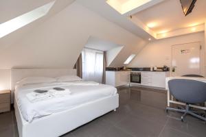 a bedroom with a bed and a desk and a chair at Hotel Kernhof Self Check-In in Zurich