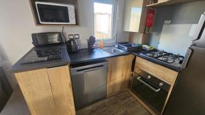 a small kitchen with a stove and a sink at Eden 1708 in Canet-en-Roussillon