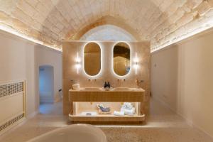 a bathroom with a sink and two mirrors at Palazzo Del Duca Hotel & Restaurant in Matera
