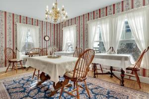 a dining room with a table and chairs and a chandelier at The Nicholson Inn in Freeport +32 photos