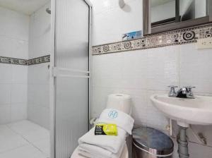 a bathroom with a sink and a shower and towels at Hotel Exito La 21 in Pereira
