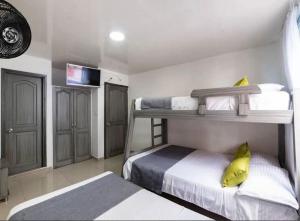 a bedroom with two bunk beds with yellow pillows at Hotel Exito La 21 in Pereira +13 photos