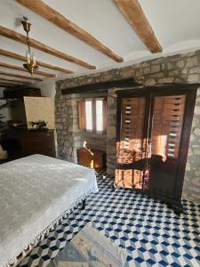 a bedroom with a bed and a stone wall at Casa de la Gallega in Bargota