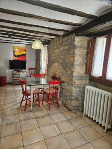 a dining room with a table and chairs and a stone wall at Casa de la Gallega in Bargota