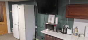 a kitchen with a white refrigerator and a microwave at Attic rooms-Bēniņu istabas in Jelgava +14 photos