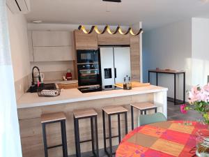 a kitchen with a counter with stools in it at Maison individuelle 6 personnes in Coux