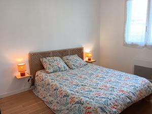 a bedroom with a bed with two lamps on two tables at Maison individuelle 6 personnes in Coux