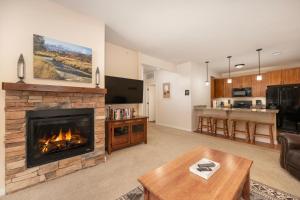 a living room with a fireplace and a kitchen at Ten Mile G201 in Granby