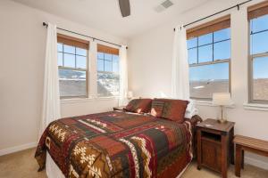 a bedroom with a bed with a table and windows at Ten Mile G201 in Granby