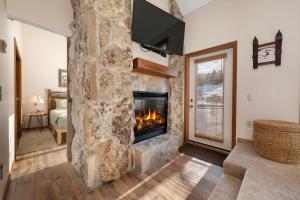 a fireplace in a living room with a stone wall at Mountainside Unit B-20 in Granby