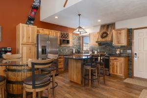a kitchen with wooden cabinets and bar stools at Mountainside Unit B-20 in Granby +22 photos