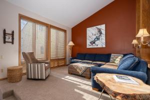 a living room with a blue couch and a table at Mountainside Unit B-20 in Granby