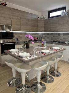 a kitchen with a table with chairs and wine glasses at La casa di Gio' Lake Maggiore Near Leonardo in Dormelletto