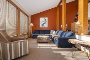 a living room with blue furniture and orange walls at Mountainside Unit B-20 in Granby