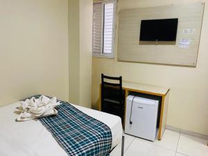 a room with a bed and a tv on a wall at Gaivota Hotel in Eldorado dos Carajás