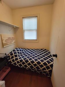 a bedroom with a bed in a room with a window at Esjacpe Guest House 2 in Boston +8 photos