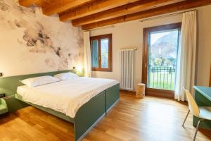 a bedroom with a bed and a large window at Contra' Contarini in Campolongo Sul Brenta