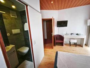 a bathroom with a toilet and a room with a desk at Hotel Pfaff in Triberg