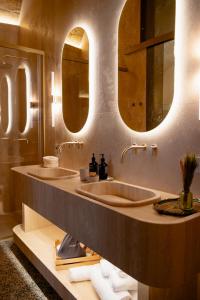 two sinks in a bathroom with two mirrors at Palazzo Del Duca Hotel & Restaurant in Matera +101 photos