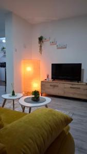 a living room with two tables and a flat screen tv at SAMI APARTMAN in Niš