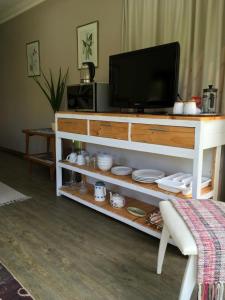 a living room with a tv on a entertainment center at Plovers Rest in George