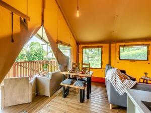 a living room with a couch and a table at Little North Field Family Safari Tent Glamping near Harrogate in Harrogate