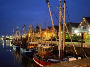 a group of boats docked in a harbor at night at Pension Blaue Nordseewelle in Neuharlingersiel