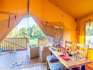 a room with a table and chairs on a deck at Little North Field Family Safari Tent Glamping near Harrogate in Harrogate +29 photos