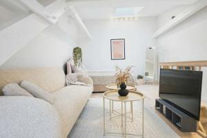 a living room with a couch and a tv at Cozy Oasis perfect for couples & solo travelers in Viborg