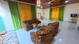 a living room with two couches and colorful curtains at Diws Holiday Bungalow in Anuradhapura
