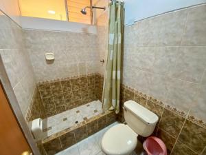 a bathroom with a toilet and a shower at Nayras Puno Hotel in Puno