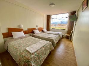 a hotel room with two beds and a window at Nayras Puno Hotel in Puno