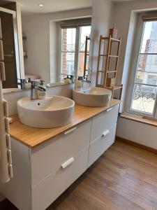 a bathroom with three sinks and two mirrors at La Fabrique - Relaxing break with Jacuzzi in Crécy-en-Ponthieu +19 photos