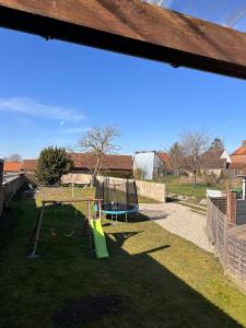 a playground with a swing set in a yard at La Fabrique - Relaxing break with Jacuzzi in Crécy-en-Ponthieu