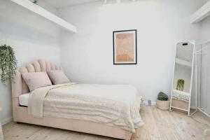 a bedroom with a pink bed and a mirror at Cozy Oasis perfect for couples & solo travelers in Viborg