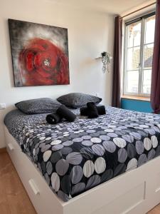 a bedroom with a bed with a painting on the wall at La Fabrique - Relaxing break with Jacuzzi in Crécy-en-Ponthieu