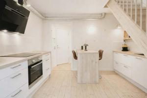 a kitchen with white cabinets and a wooden table at Cozy Oasis perfect for couples & solo travelers in Viborg +8 photos