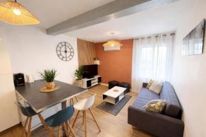 a living room with a blue couch and a table at Duplex 2 chambres Meximieux centre ville in Meximieux