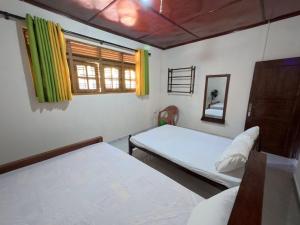 a bedroom with two beds and a window at Diws Holiday Bungalow in Anuradhapura