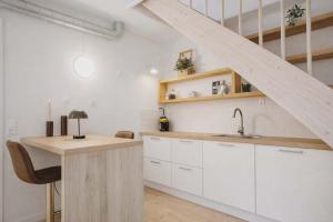 a kitchen with white cabinets and a sink at Cozy Oasis perfect for couples & solo travelers in Viborg