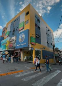 a group of people crossing a street in front of a building at Alameda Hotel Centro in Garanhuns