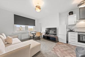 a living room with a white couch and a table at Lesmahagow Hilltop View in Lesmahagow