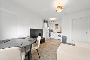 a living room with a dining room table and a kitchen at Lesmahagow Hilltop View in Lesmahagow +17 photos