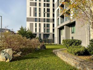 a building with a grassy yard in front of a building at Cloud 9 Bucharest Residence in Bucharest
