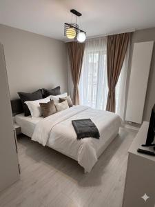 a bedroom with a large white bed and a window at Cloud 9 Bucharest Residence in Bucharest +2 photos