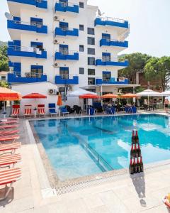 a hotel swimming pool with chairs and a building at Hotel BlueBalcony in Golem