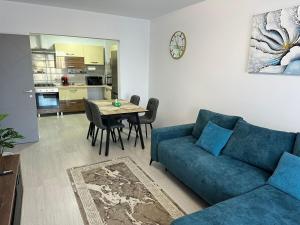 a living room with a blue couch and a table at Apartment White Tower Residential in Ploieşti
